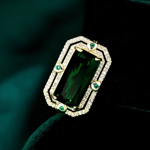 Dettaglio macro della spilla con gemma verde taglio smeraldo e micro-pavé di zirconi