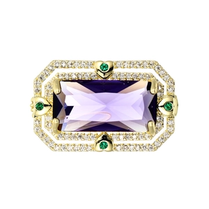 Dettaglio di anello vintage dorato con grande gemma viola e accenti di cuori verdi