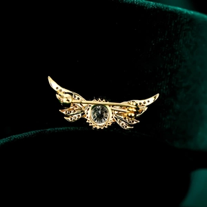Vue détaillée du dos de la broche ailes d'ange dorées avec zircon et épingle de sûreté