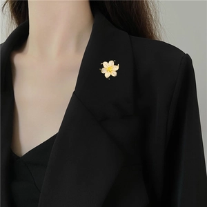 Detail of luxury zircon floral brooch pinned on a black blazer lapel for an elegant look