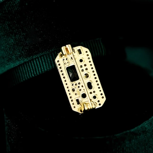 Macro shot of vintage gold brooch with dark rectangle gemstone on green velvet box