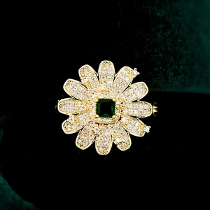 Detailaufnahme einer luxuriösen Blumenbrosche mit grünem Edelstein und Zirkonia