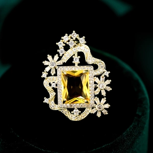 Lujoso broche de circonita con gema amarilla rectangular y detalles de estrellas de oro
