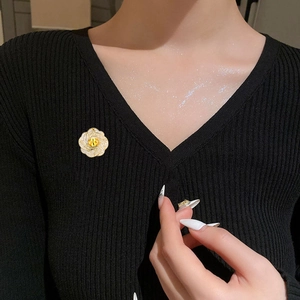 Élégante broche fleurie avec pierre jaune et cristaux blancs sur maille noire