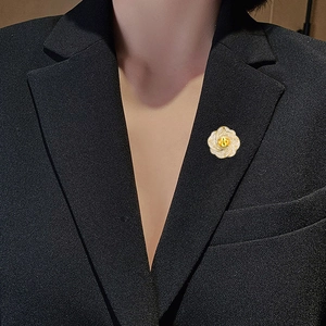 Broche florale élégante avec pierre jaune et cristaux sur un revers noir