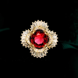 Macro detail of luxury floral brooch with red ruby center and micro-pave cubic zirconia