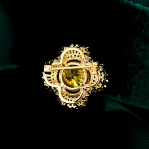 Detailed macro view showing the secure metal safety pin clasp on the back of the brooch