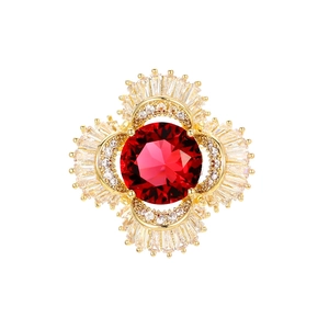 Luxurious gold brooch with a large round ruby zircon and intricate diamond halo pattern