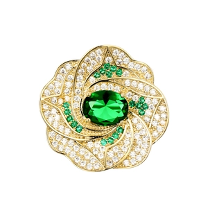 Élégante broche fleurie en or avec pétales en zircon pavés et gemme verte centrale