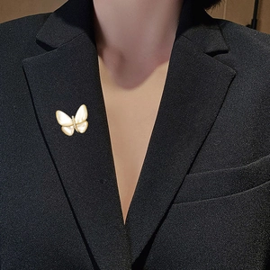 Detailansicht der Schmetterlingsbrosche mit Muschelflügeln auf schwarzem Revers