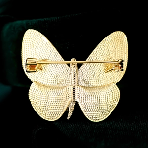 Detailansicht der Rückseite einer goldenen Schmetterlingsbrosche mit Sicherheitsverschluss