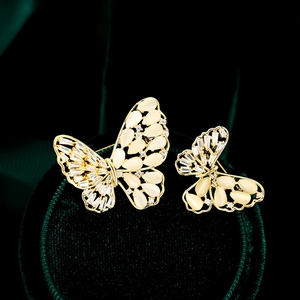 Detailopname van elegante vlinderspelden met opaalachtige stenen en zirkoonaccenten