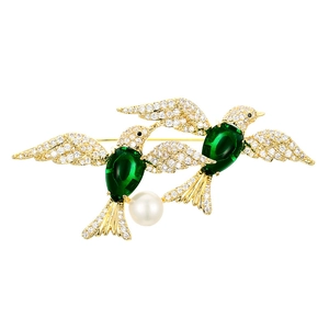 Elegant gold double bird brooch with green emerald gemstones and a hanging pearl