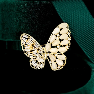 Macro-opname van gouden vlinderbroche met zirkoonvleugels op donkergroen fluweel