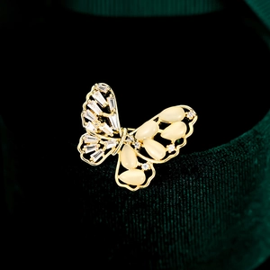 Elegante vlinderbroche met zirkonia en opaalstenen op een groene fluwelen achtergrond