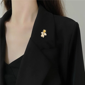 Detailansicht der Goldfisch-Brosche mit Zirkonia auf einem schwarzen Blazer-Revers