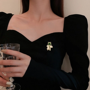 Exquisite Teddybär-Brosche in Gold mit Smaragd-Edelstein auf schwarzem Kleid