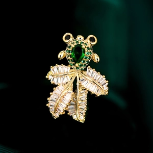 Exquisite goldene Goldfisch-Brosche mit grünen Birnen-Edelsteinen auf Seidenstoff