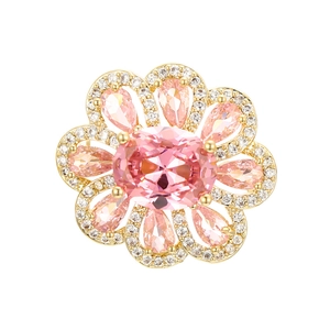 Close-up of golden floral pin with oval pink zircon stone and petal-shaped gems
