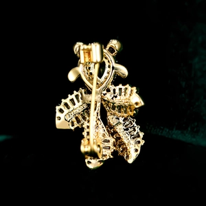 Makroansicht der Rückseite der Gold-Fischbrosche mit sicherem Drehverschluss-Mechanismus