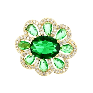 Exquisite flower brooch featuring green oval zircon and sparkling white crystals in gold