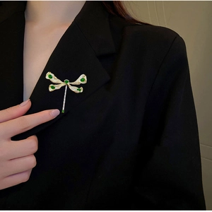 Elegante Libellen-Brosche mit grünen Edelsteinen und Kristallen auf schwarzem Revers