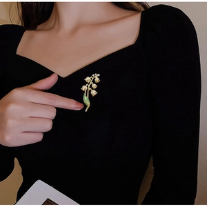 Broche élégante en muguet avec feuilles dégradées vertes sur tissu noir