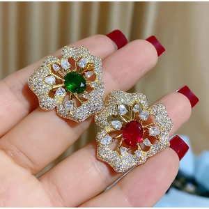 Eleganter vergoldeter Blumen-Brosche mit weißen Kristallen und roten oder grünen Steinen