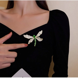 Elegante spilla a libellula con gemme verdi e cristalli bianchi su base dorata
