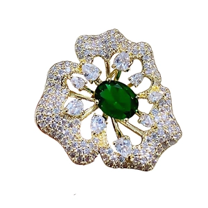 Eleganter goldener Blumen-Brosche mit smaragdgrünem Edelstein und weißen Kristallen