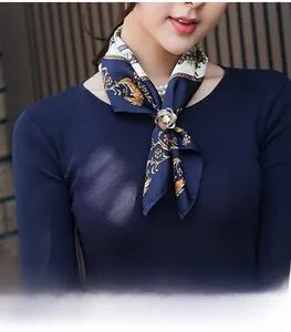 Gros plan d'un foulard en soie imprimé fleuri avec une boucle dorée à perle