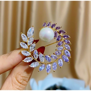Elegant gold flower wreath brooch with purple marquise zircon and a white pearl accent