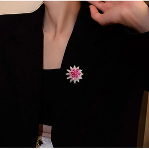 Detail of pink crystal flower brooch with zircon stones pinned on a black suit jacket