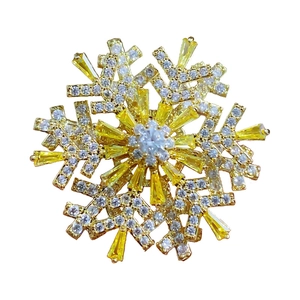 Rotating golden snowflake brooch with cubic zirconia crystals and yellow gems