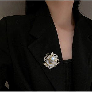 Vue détaillée de l'élégante broche rose avec zircons AAA et perle sur un revers noir