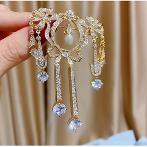 Élégante broche nœud dorée avec pompons en zircone et perle pour vestes de luxe