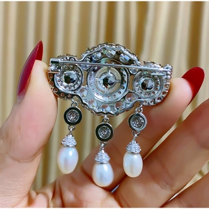Macro view of vintage tassel brooch with zircons and hanging teardrop pearls