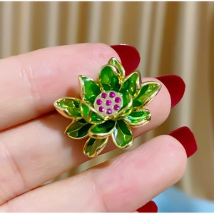 Vintage lotus brooch with green enamel petals and purple zircon in a layered metal design