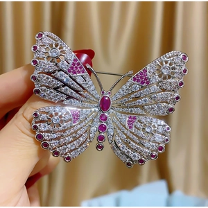Elegante broche de mariposa con piedras rosas y cristales en metal plateado fino
