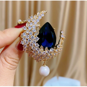 Spilla a luna con cristalli scintillanti, gemma blu scuro e perla in finitura oro
