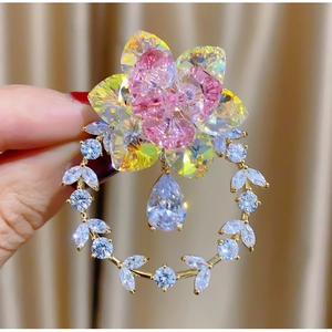 Spilla a ghirlanda floreale dorata con cristalli rosa e pendente a goccia di diamante