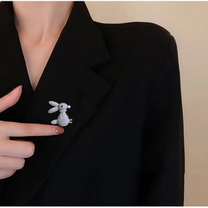 Elegant gold rabbit brooch with pave-set zircons pinned on a black suit lapel