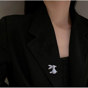 Elegant gold-tone 3D rabbit brooch with micro-paved sparkling crystals on a black blazer