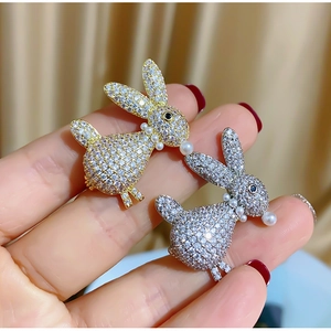 Close-up of gold and silver rabbit brooches with sparkling cubic zirconia and pearls