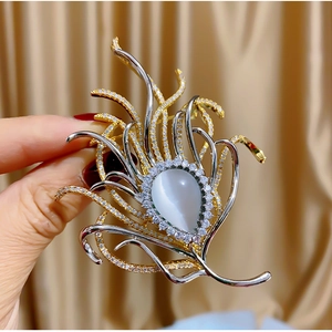Elegant peacock feather brooch with a large teardrop opal and sparkling crystals