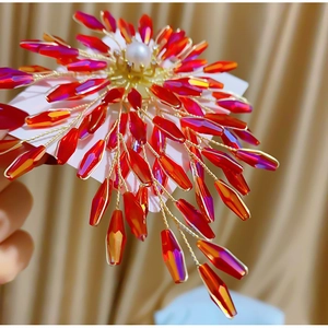 Broche fleur tissée main avec cristaux rouges, fil doré et centre en perle blanche