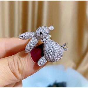 Macro shot of silver rabbit brooch with pave zircon stones and elegant pearl accents