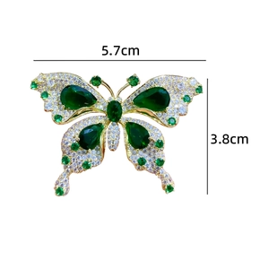 Détail de la broche papillon de luxe avec pierres émeraude et cristaux brillants