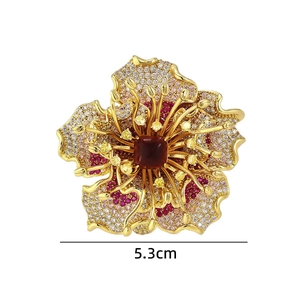 Close-up of a 5.3cm peony brooch with red cubic zirconia and detailed gold filigree
