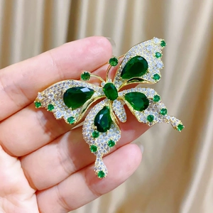 Vue détaillée de la broche papillon en émeraude de luxe avec pavé de diamants fins